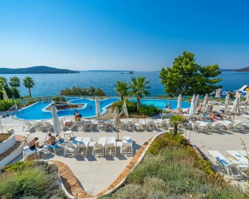 Swimming pool and sunbeds overlooking the sea at Roan campsite Amadria Park Trogir.